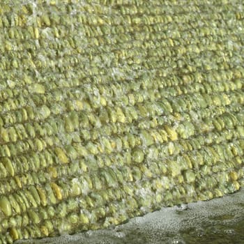 Cascade of water over green pebbles