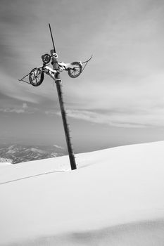 Old and weathered pillar of an abandoned skilift line in candid ski slope covered by thick powder snow with wide panorama