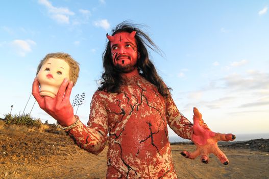 Latin American Man with Long Hairs Masked as a Devil in the Desert