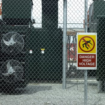 Danger high voltage sign on a fence