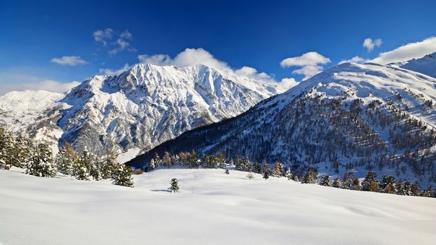 Off piste snowy ski slope in majestic high mountain scenery during ski touring activity in the italian Alps