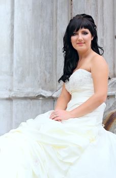 Girl in the wedding dress sitting at a stones