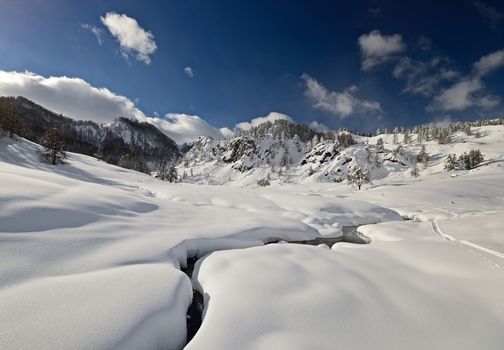 Off piste snowy ski slope in majestic high mountain scenery during ski touring activity in the italian Alps