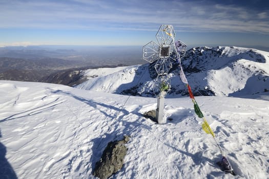 The christhian cross marking the mountain summti in the italian Alps