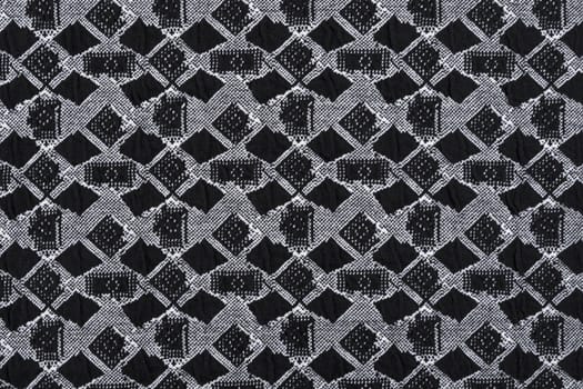 Material in geometric patterns, a grey textile background.