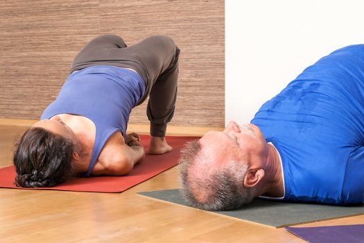 An image of some people doing yoga exercises - Setu Bandha Sarvangasana