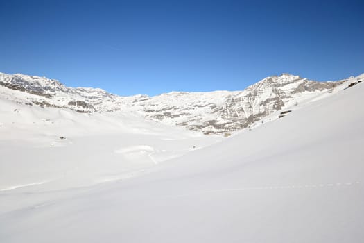 Candid off piste ski slope in scenic background of high mountain peaks, Gran Paradiso National Park, italian Alps