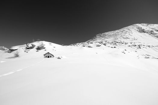 Little chapel high in the mountains with powder snow and back country ski tracks near Gran Paradiso National Park