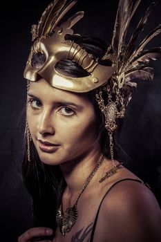 Valkyrie, Golden statue concept. Arty portrait of model with golden mask and shiny lashes. Perfect sporty body. Long hair. Profile. Performance