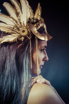 Vintage warrior woman with gold mask, long hair brunette. Long hair. Profile. Studio shot