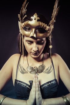 Warrior woman with gold mask, long hair brunette. Long hair. Profile. Studio shot