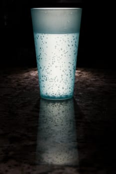 Bright lit cup lit up with a reflection of the cup on marble