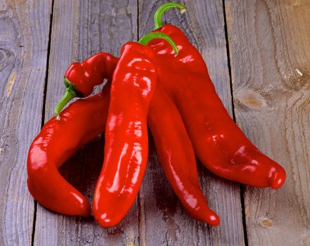 Arrangement of Perfect Raw Ripe Red Ramiro Peppers isolated on Rustic Wooden background