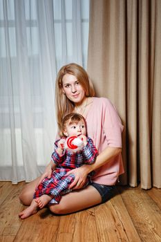 Attractive young blond mother holding her baby in her arms