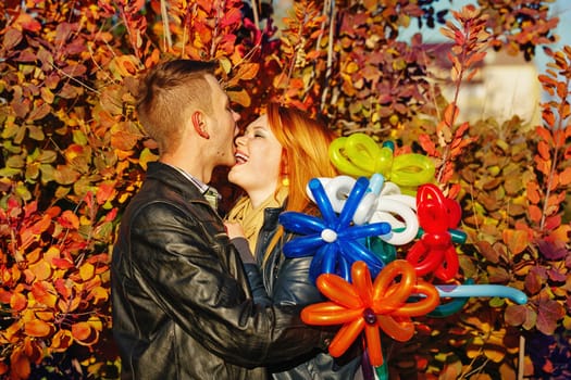 Young couple tenderly and lovingly playing with each other in the autumn park