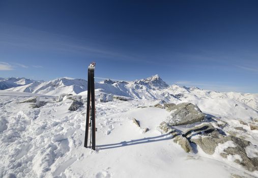 Pair of back country ski on the summit cairn with superb view of the italian alpine arc