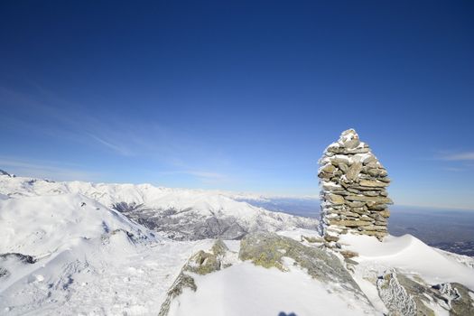 High mountain range with the majestic M. Viso (3841 m) in the background and the summit stone cairn