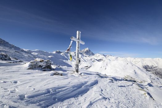 The christhian cross marking the mountain summti in the italian Alps