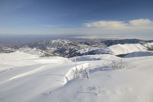 Candid off-piste ski slope in scenic background of mountain peaks, valleys and plain. Piedmont, Italian Alps