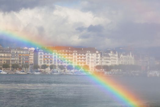 View of Geneva from the lake Lehman through a rainbow in the fountain, Switzerland, Europe