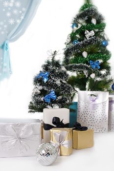 Christmas tree decorated with blue ornaments and presents over white