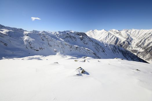 Candid off-piste ski slope in scenic background of mountain peaks, valleys and plain. Piedmont, Italian Alps