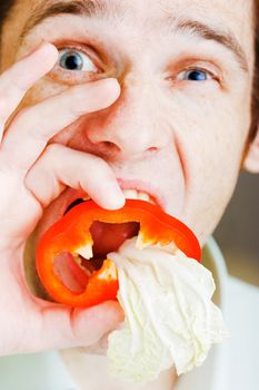 Young man with red pepper. Face close-up. humor