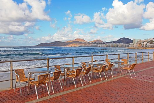Spain. Canary Islands. Gran Canaria island. Las Palmas de Gran Canaria city. An open-air cafe on the Las Canteras beach at sunset