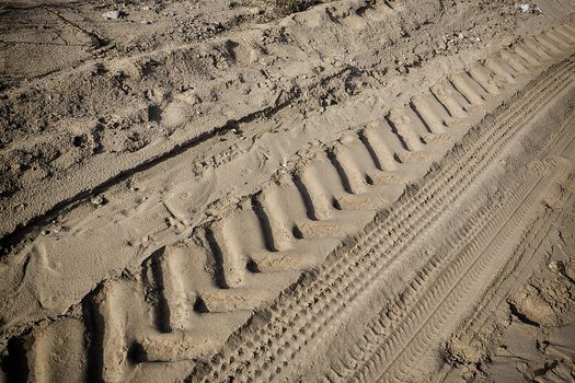 Tractor tire tracks on beach sand. Horizontal shot