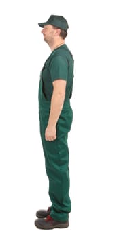 Side view. Worker in green overalls. Isolated on a white background