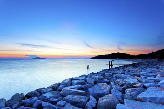 Sunset sea stones along coast