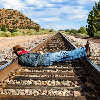 famous cow-boy boots and feets across train tracks 