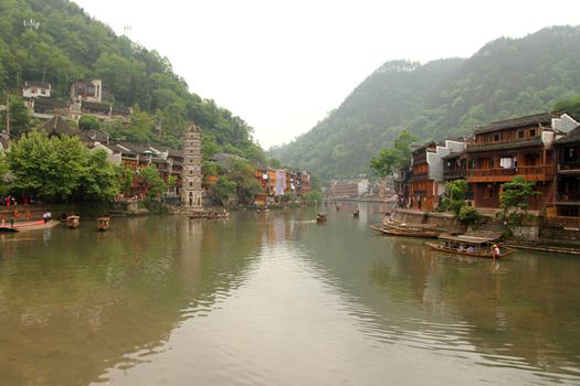 FENGHUANG - MAY 12: Wooden boat and wooden houses at tuojiang river in fenghuang ancient town on May 12, 2011 in Fenghuang, China.