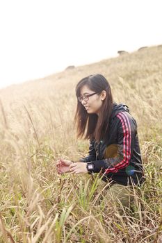 Asian woman in sunset grasses