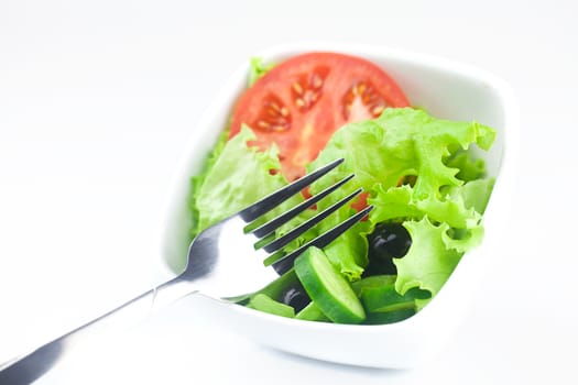 fork,black olive,lettuce, tomato, cucumber and pepper in a bowl