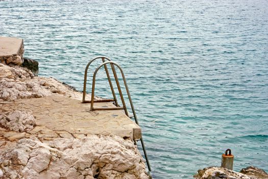 Ladder on rocky coast of the Mediterranean sea