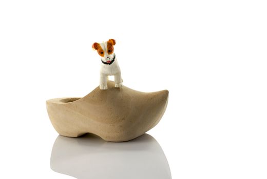 plastic toy dog on dutch wooden show isolated on white