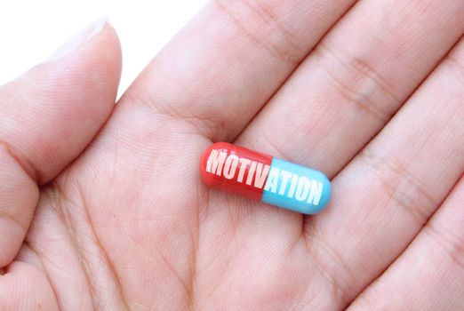 Hand holding a capsule labeled motivation 