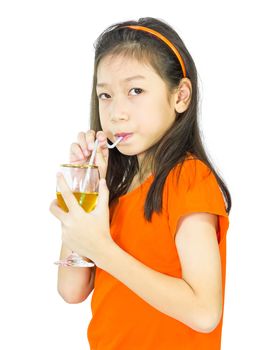 Asian young girl drinks orange juice using a drinking straw, isolated over white