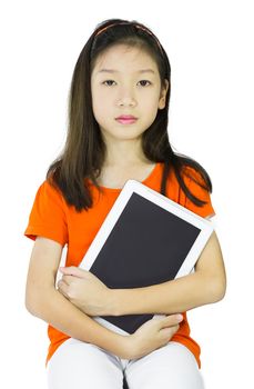 Asian young girl is holding tablet while sitting at table, isolated over white