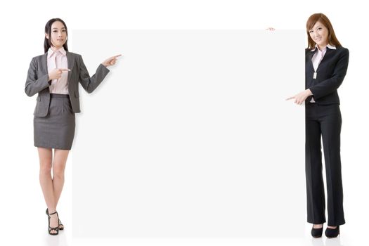Two Asian business women introduce and hold a blank board, full length portrait isolated on white background.