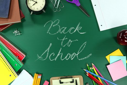 Back to School Supplies on Green Chalkboard Background