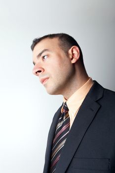 Young business man that looks worried or contemplative isolated over a silver background.