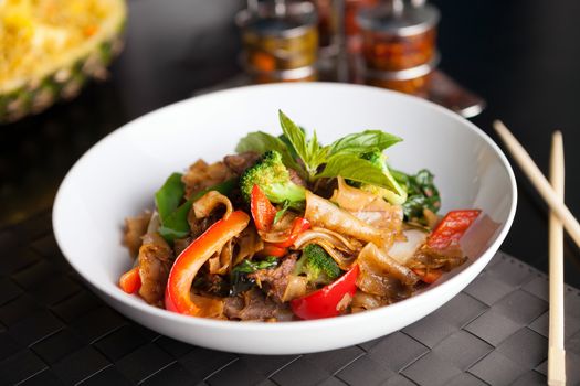 Pad kee mao drunken noodle thai disk with beef and mixed vegetables.