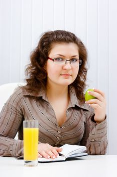 Young woman with a notebook and apple