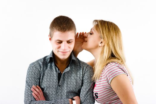 young woman whispering a secret to a man's ear