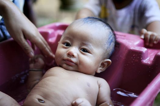 Mom washes young son. Indonesia, Bali