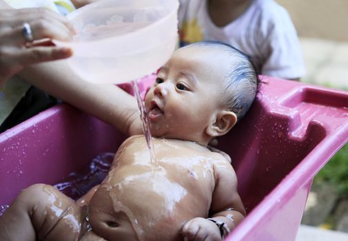 Mom washes young son. Indonesia, Bali