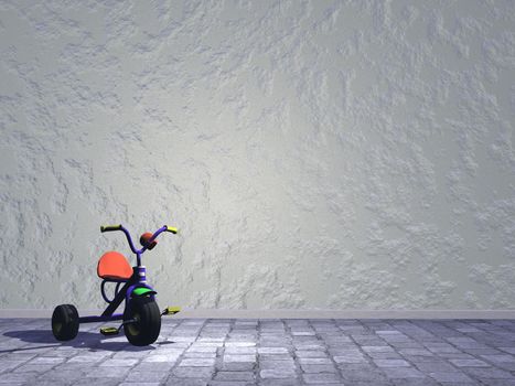 Child tricycle in the street next to a wall