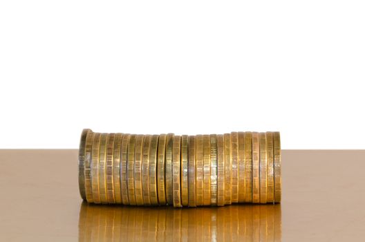 A stack of coins, placed horizontally on a Golden surface, isolated on white background